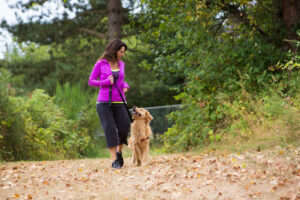 girl walking dog in park