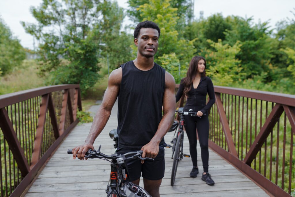 Young couple walking on a bridge with their bikes