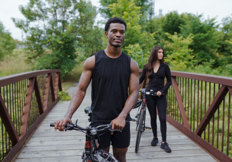 Young couple walking on a bridge with their bikes