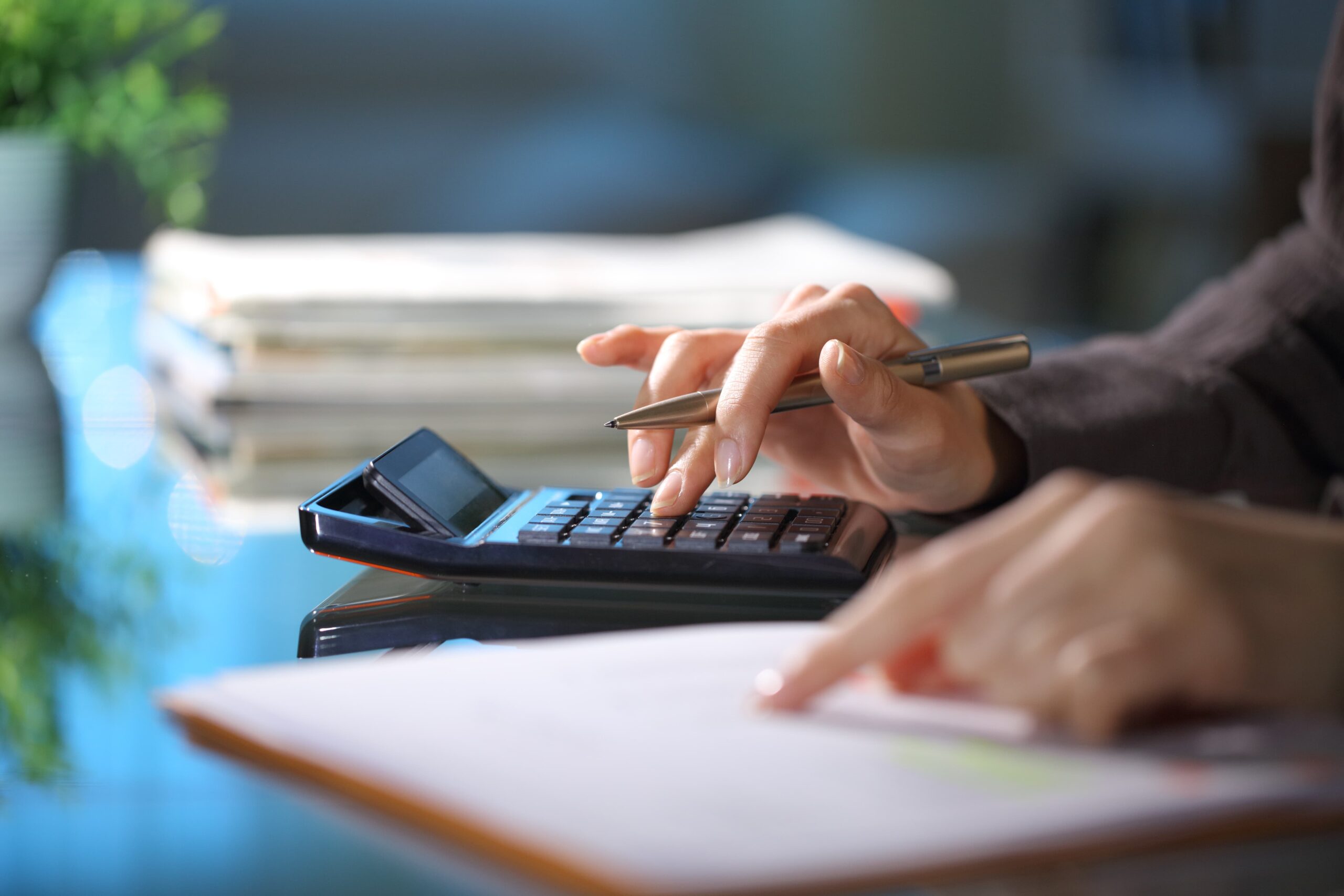 young professional budgeting with a calculator and taking notes