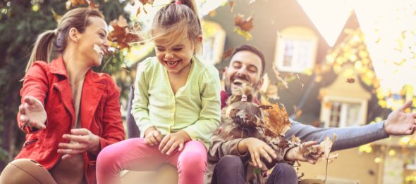 family playing in the autumn leaves